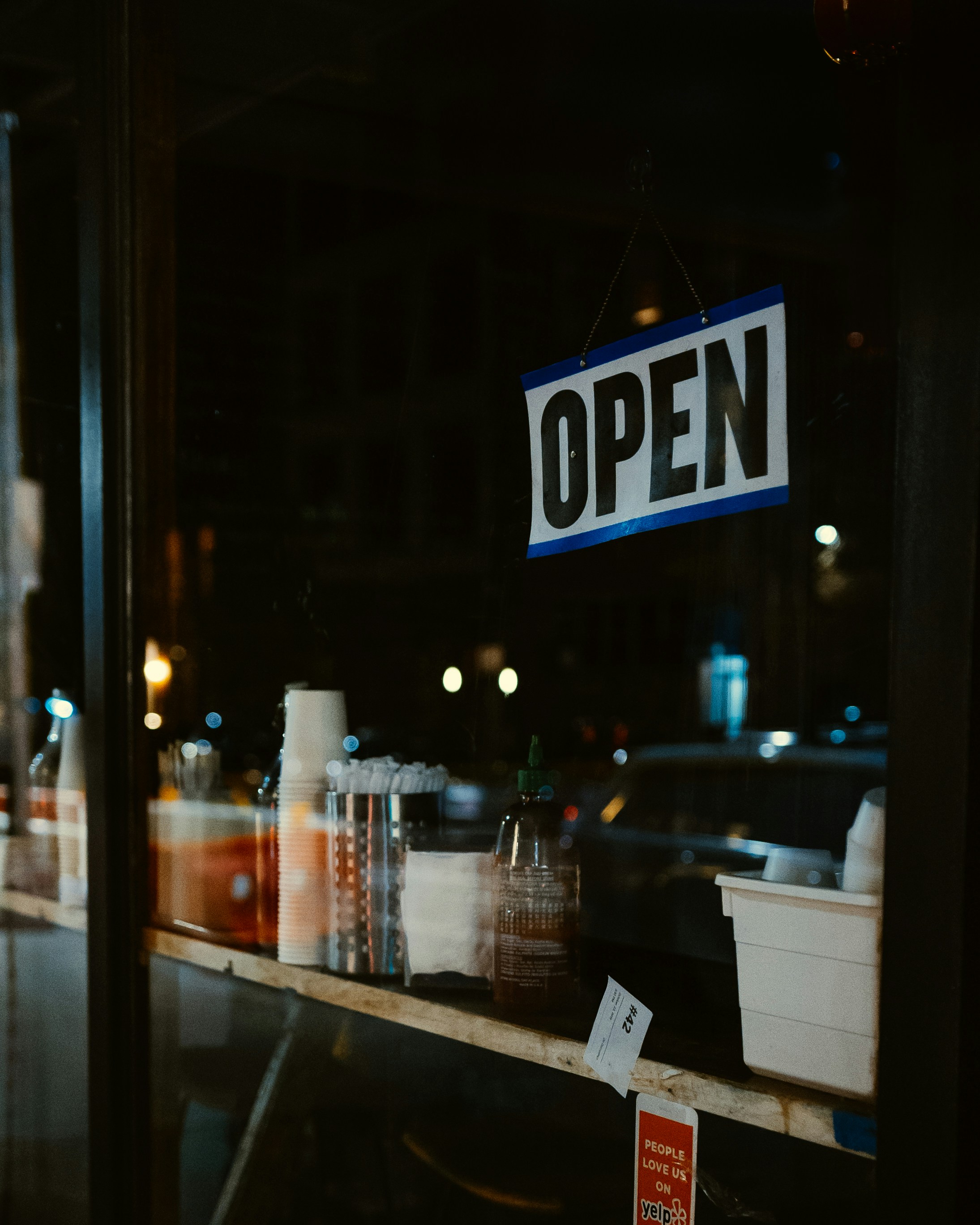 A customer pays at the counter of a busy salon — tablet POS, contactless reader