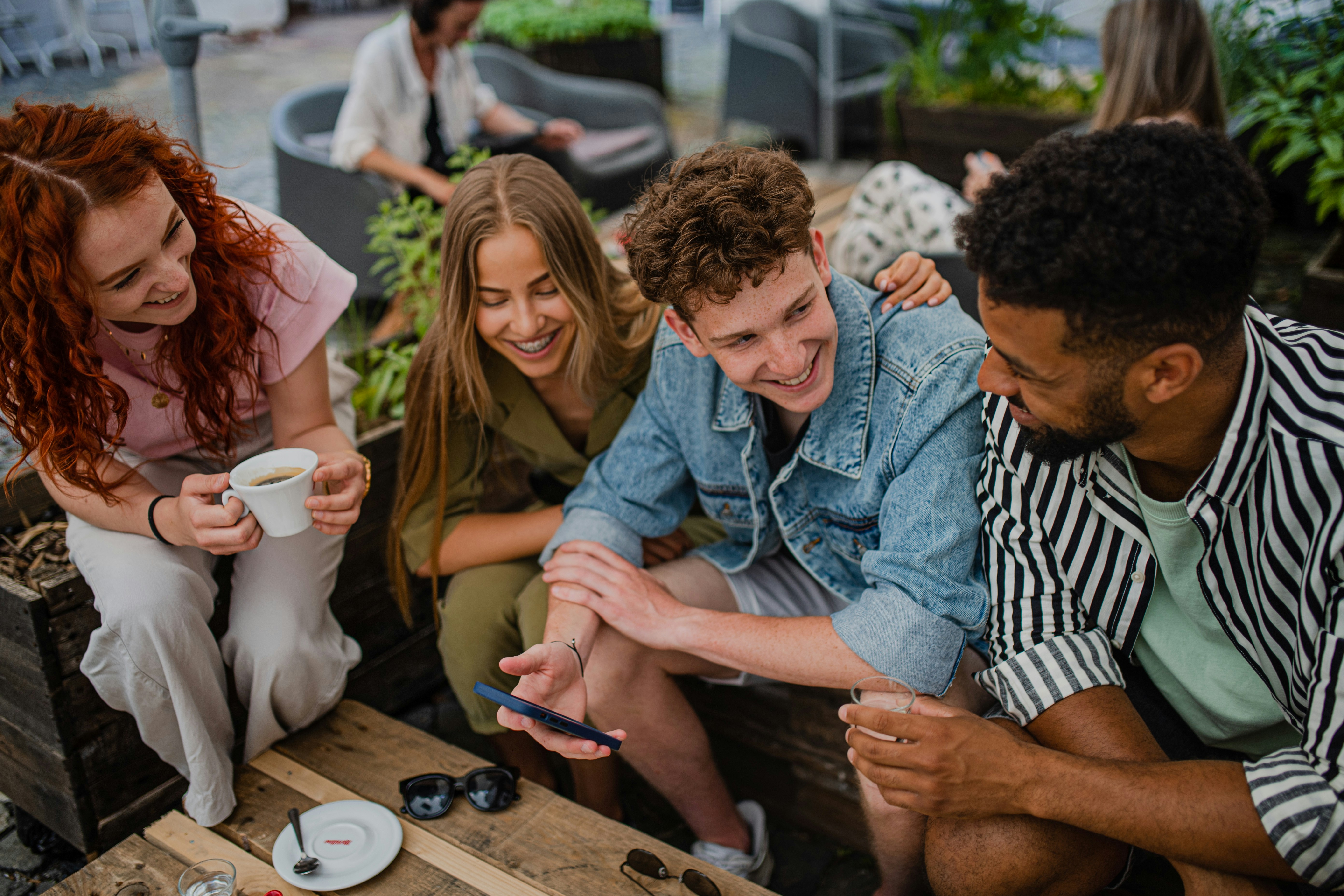 A group of friends sharing a moment over a phone — the bill, split in seconds